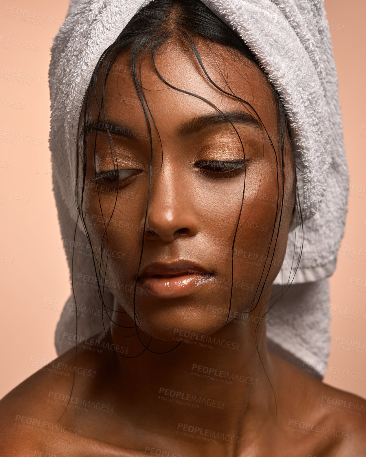 Buy stock photo Closeup shot of a beautiful young woman with her hair wrapped in a towel against a brown background