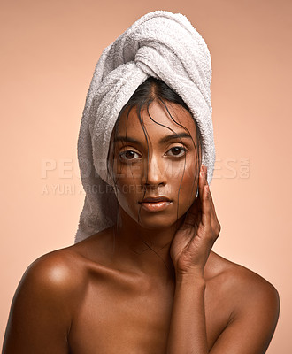 Buy stock photo Portrait of a beautiful young woman with her hair wrapped in a towel a brown background