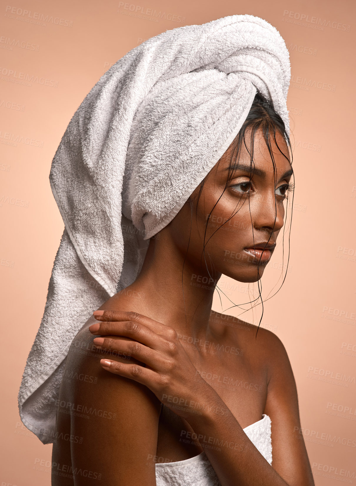 Buy stock photo Shot of a beautiful young woman with her hair wrapped in a towel against a brown background