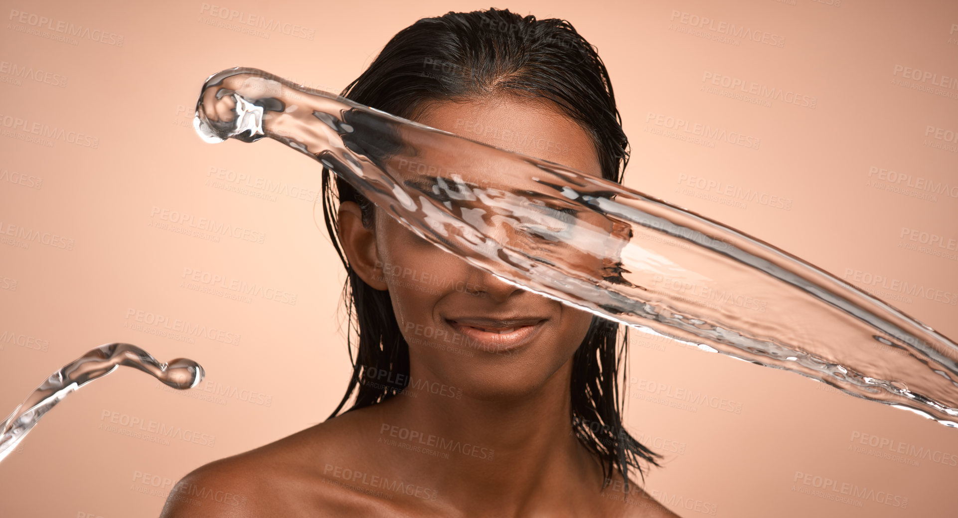 Buy stock photo Shot of a young attractive woman doing her daily skincare routine against a brown background