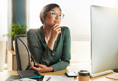 Buy stock photo Shot of a young businesswoman looking at her computer screen at work