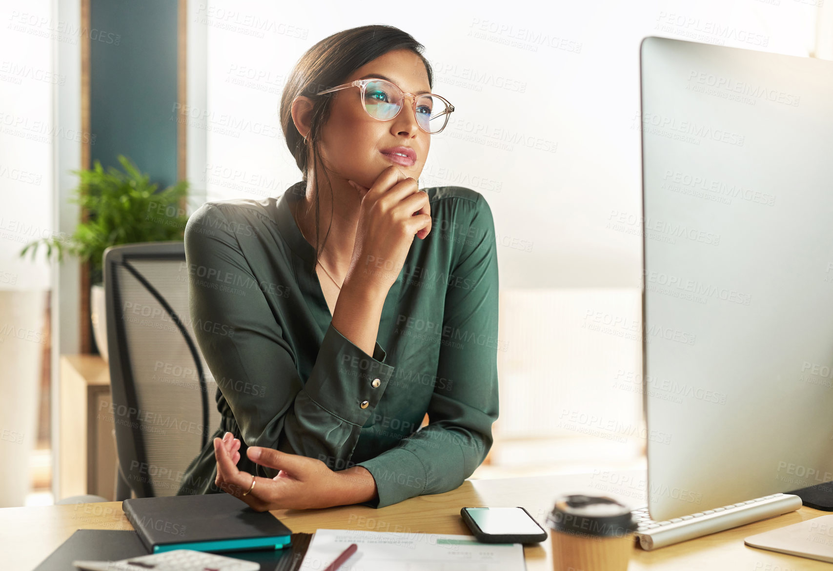 Buy stock photo Shot of a young businesswoman looking at her computer screen at work