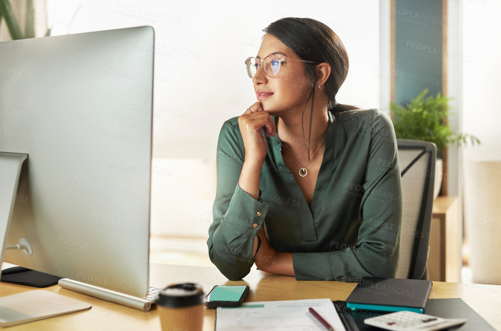 Buy stock photo Shot of a young businesswoman looking at her computer screen at work