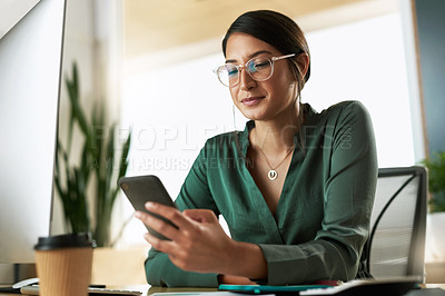 Buy stock photo Shot of a young businesswoman using her smartphone to send text messages