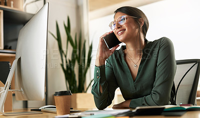 Buy stock photo Shot of a young businesswoman taking a call on her smartphone at work