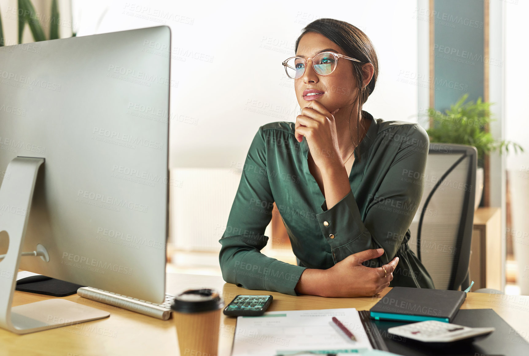 Buy stock photo Shot of a young businesswoman looking at her computer screen at work