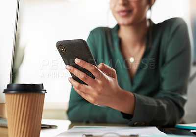 Buy stock photo Shot of a businesswoman using her smartphone at her desk