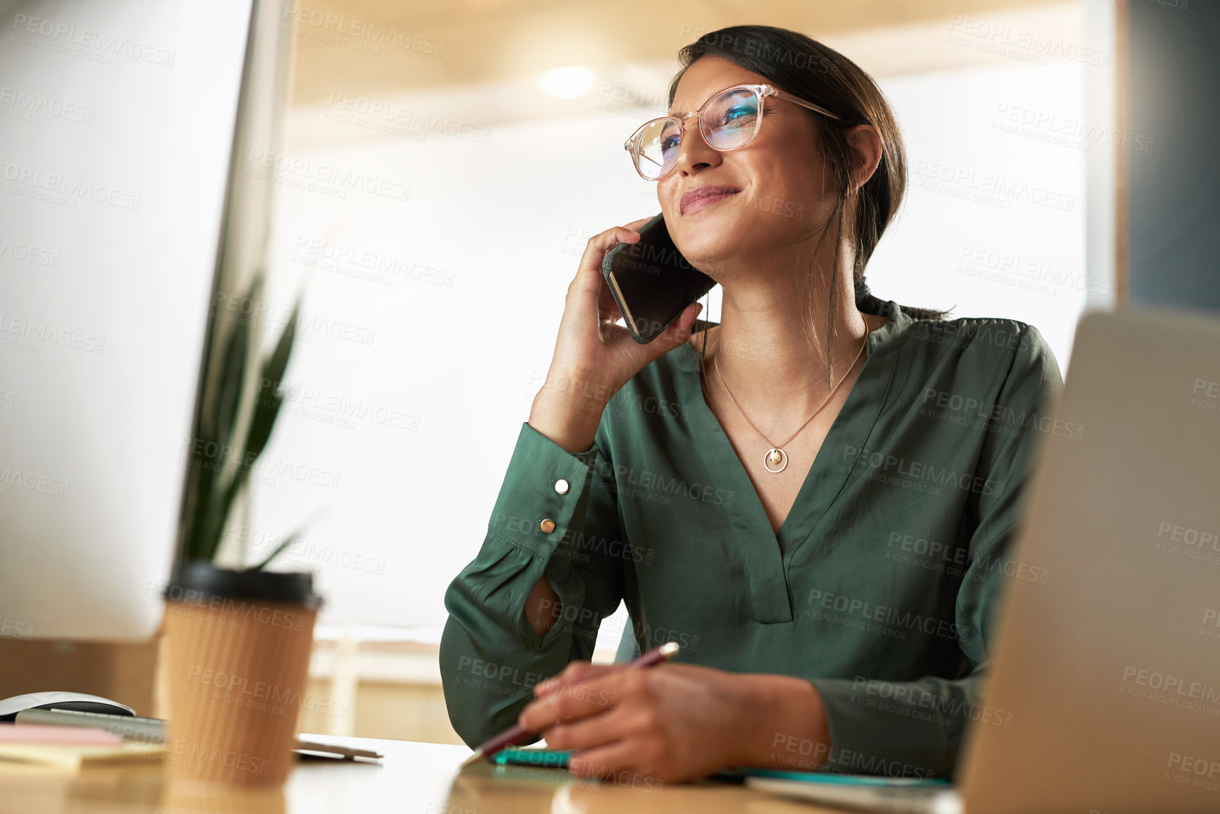 Buy stock photo Shot of a young businesswoman taking a call on her smartphone at work