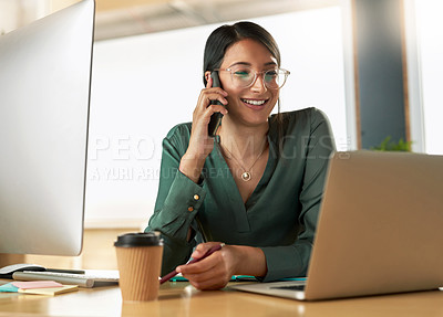 Buy stock photo Shot of a young businesswoman taking a call on her smartphone at work