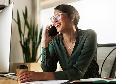 Buy stock photo Shot of a young businesswoman taking a call on her smartphone at work