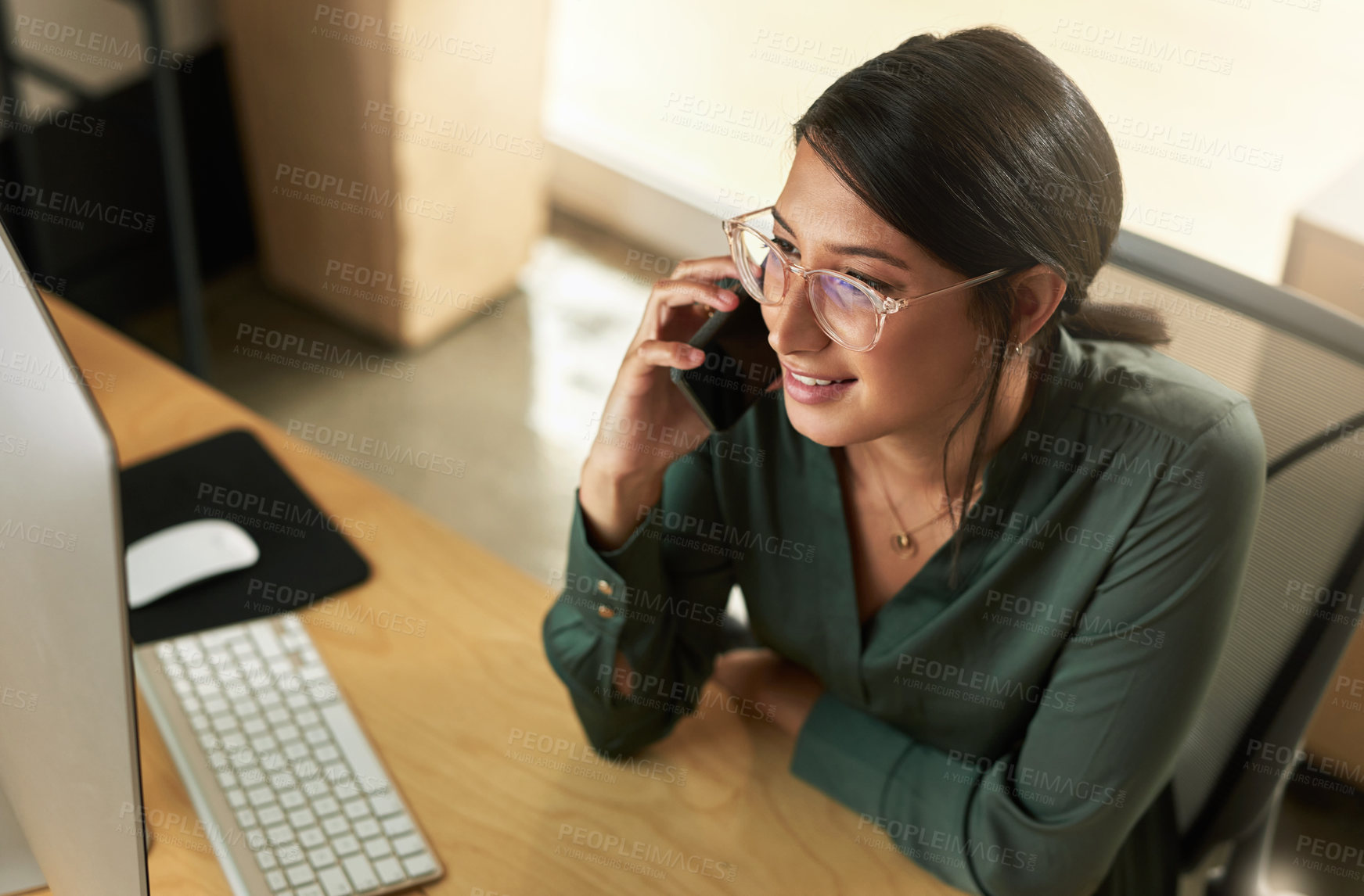 Buy stock photo Shot of a young businesswoman taking a call on her smartphone at work