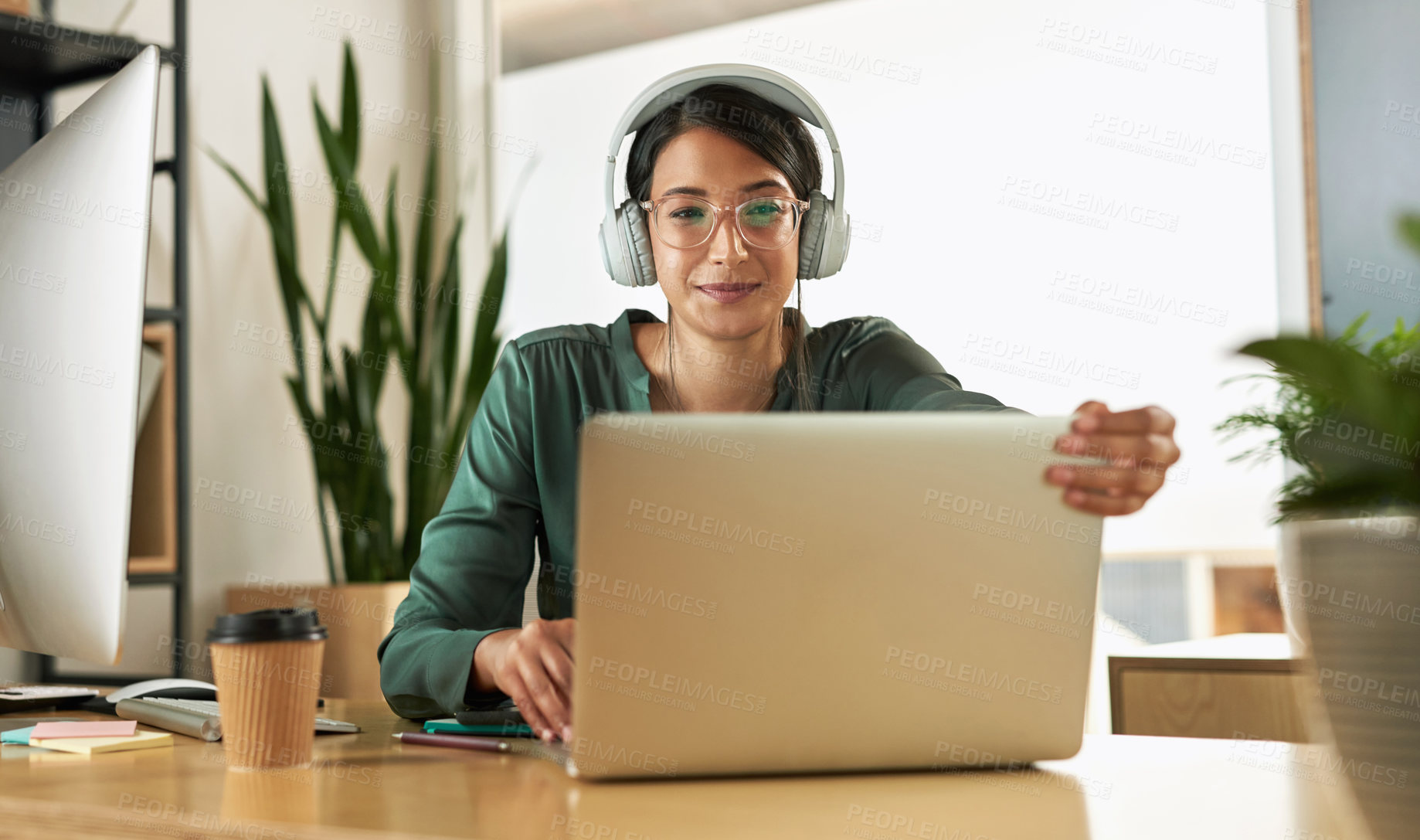 Buy stock photo Shot of a young businesswoman using her laptop to host a video conference at work