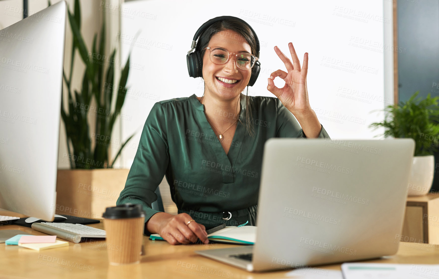 Buy stock photo Shot of a young businesswoman using her laptop to host a video conference at work