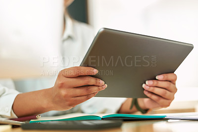 Buy stock photo Shot of a businesswoman using her digital tablet at her desk