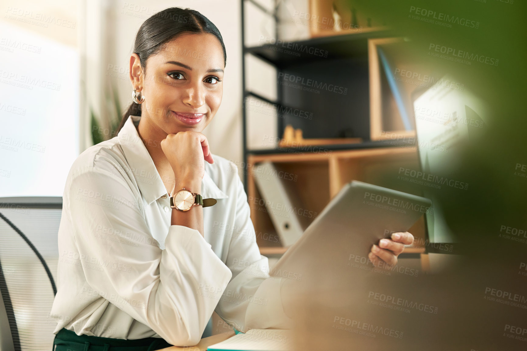 Buy stock photo Shot of a young businesswoman using her digital tablet at her desk