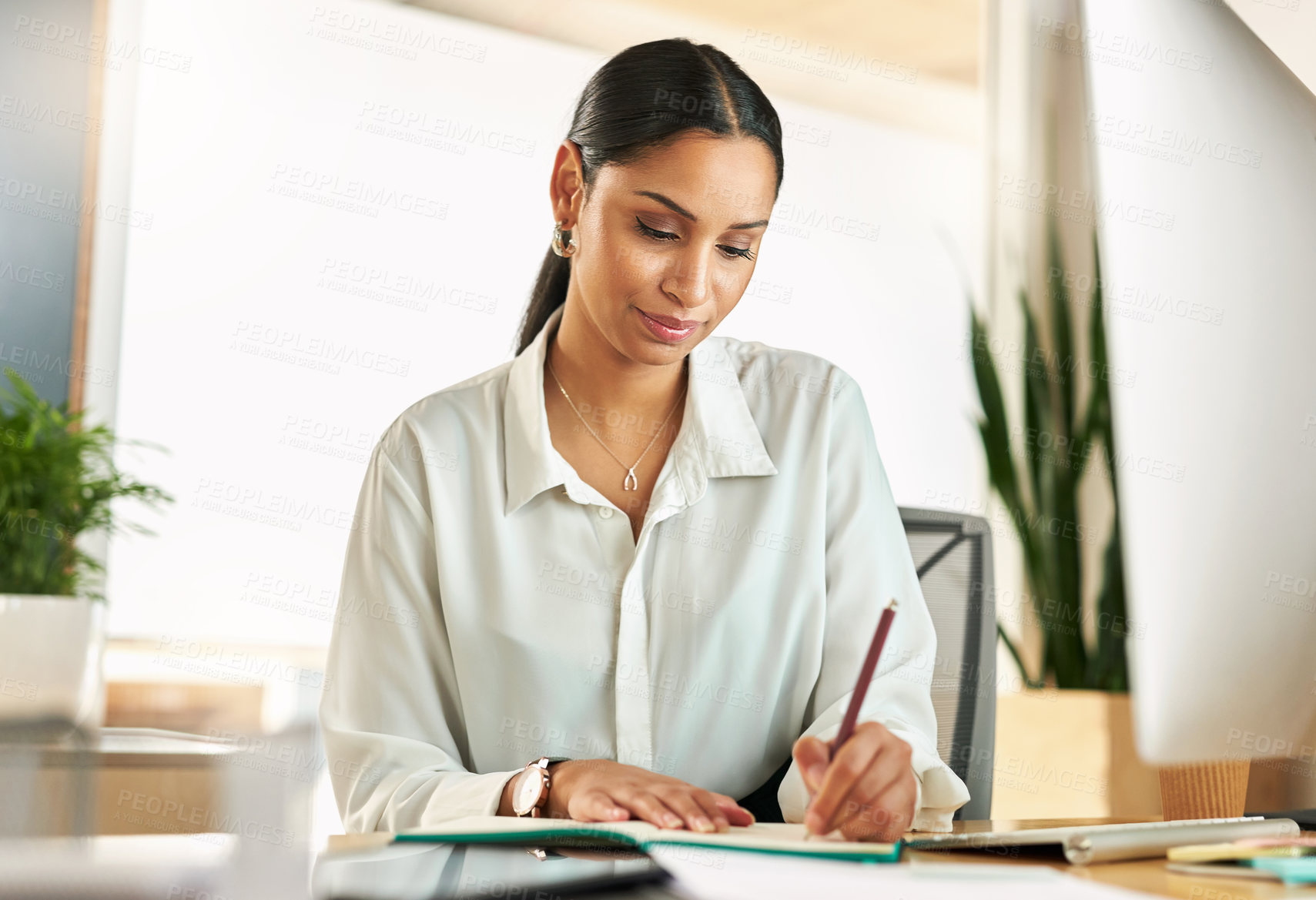 Buy stock photo Shot of a young businesswoman compiling notes at work