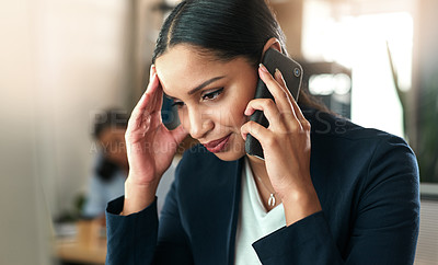 Buy stock photo Shot of a young businesswoman taking a call on her smartphone at work