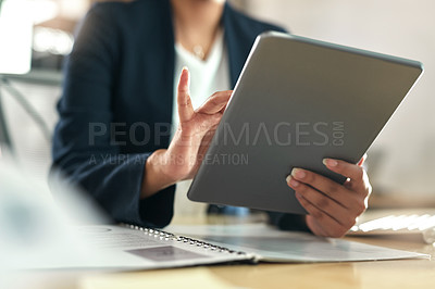 Buy stock photo Shot of a businesswoman using her digital tablet at her desk