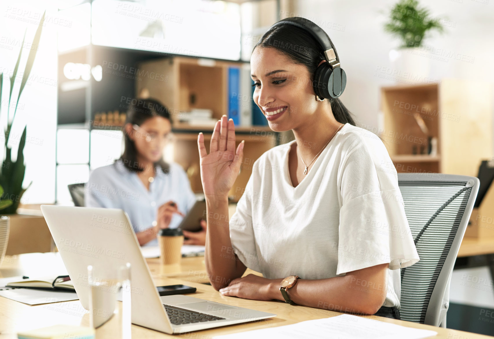 Buy stock photo Shot of a young businesswoman using her laptop to host a video conference at work