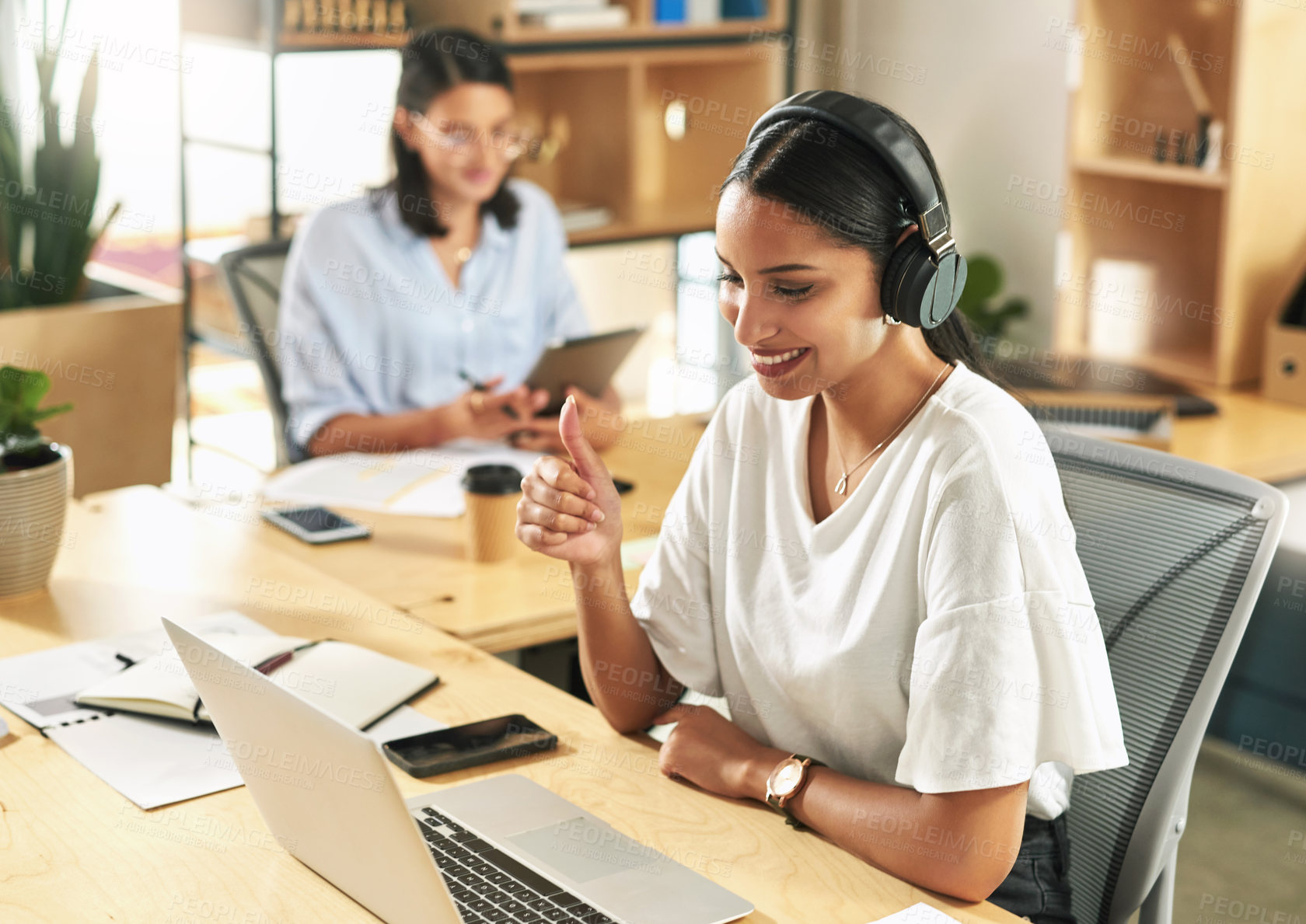 Buy stock photo Shot of a young businesswoman using her laptop to host a video conference at work