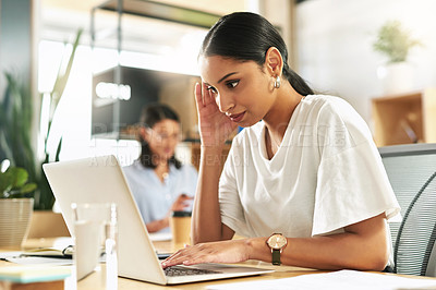 Buy stock photo Shot of a young businesswoman using her laptop at work