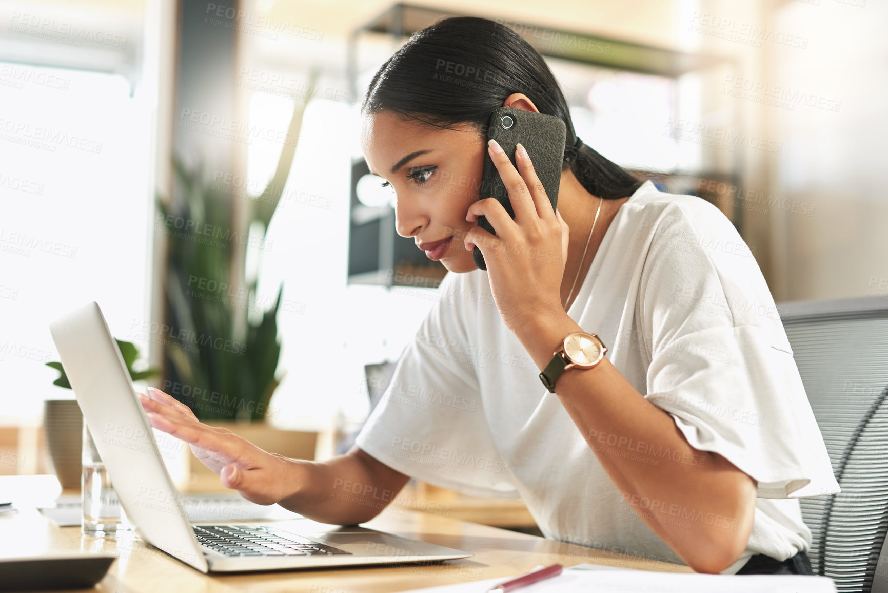 Buy stock photo Shot of a young businesswoman taking a call on her smartphone at work