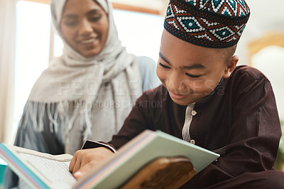 Buy stock photo Shot of a young muslim mother and her son reading in the lounge at home