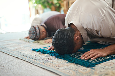 Buy stock photo Shot of a young muslim couple and their son praying in the lounge at home