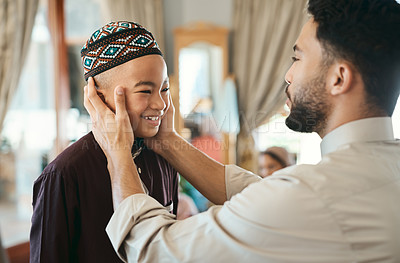 Buy stock photo Affectionate, loving and caring Muslim father and son talking and bonding on Eid holiday. Cute, smiling and happy Islamic child listening to advice from dad while wearing a traditional outfit