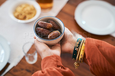 Buy stock photo Shot of a muslim woman holding a bowl of dates to break her fast