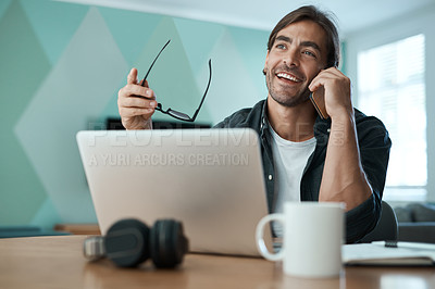 Buy stock photo Shot of a young man using a laptop while on a call at home