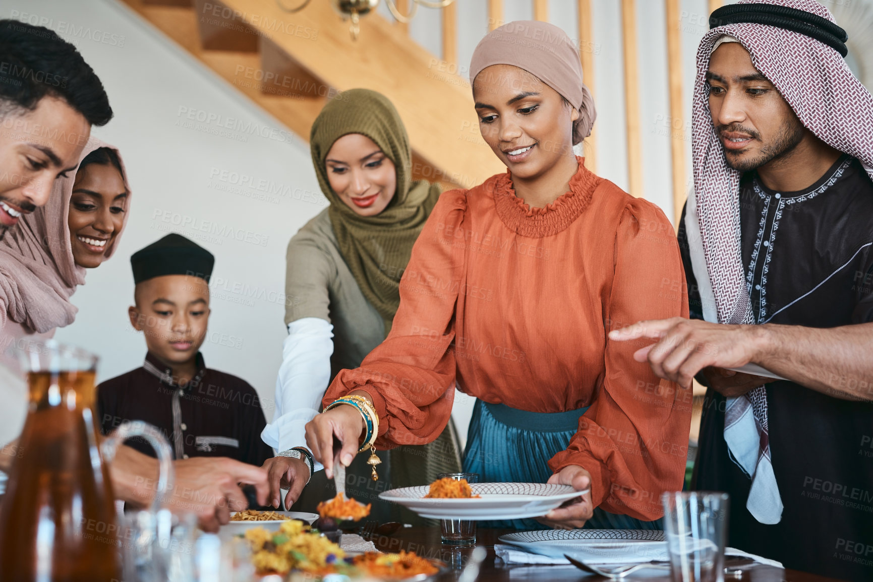 Buy stock photo Shot of a muslim family dishing lunch for themselves