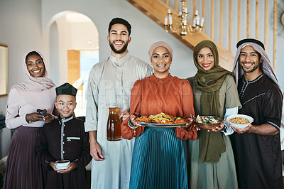 Buy stock photo Smiling, festive muslim family celebrating eid or ramadan party lunch together holding dishes of food at home. Happy, traditional islamic religion group of friends enjoying cultural holiday