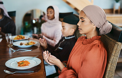 Buy stock photo Shot of a muslim family praying before eating