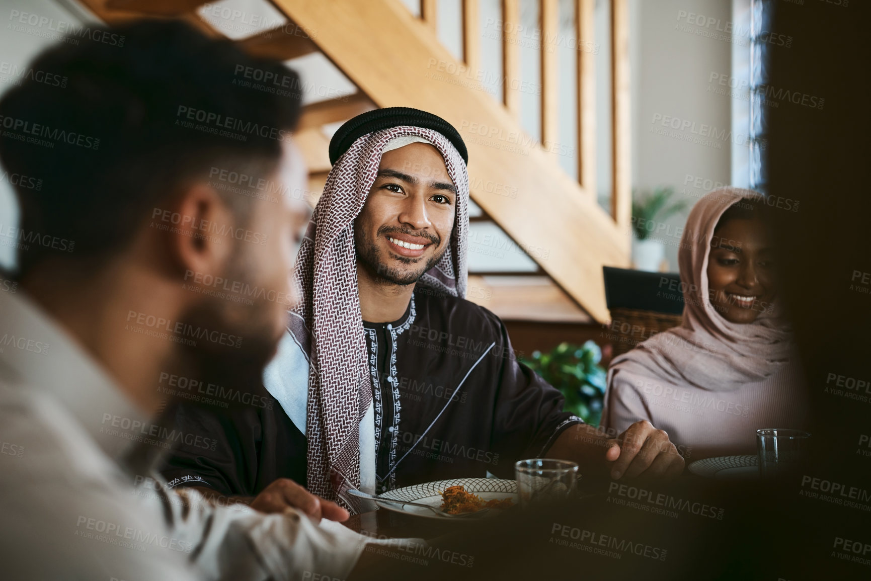 Buy stock photo Muslim, arab and islamic man enjoying a meal for eid, ramadan or breaking fast with family while celebrating religion, holy culture and islam faith. Happy, smiling and spiritual guy eating lunch