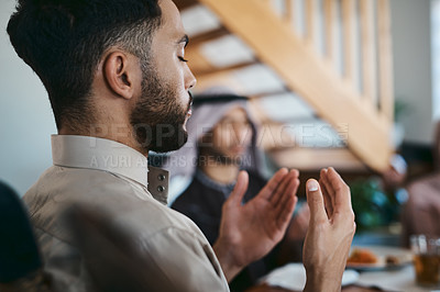 Buy stock photo Muslim, praying and religion while sitting with family and say a dua or prayer before breaking fast during the holy month of Ramadan. Religious man lifting his hands to pray during eid or iftar meal