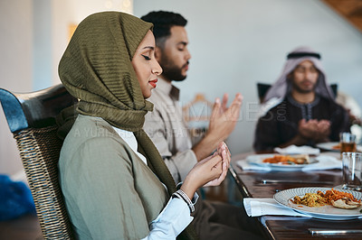 Buy stock photo Shot of a muslim family praying before they break their fast