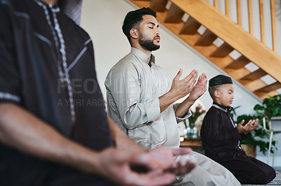 Buy stock photo Muslim family praying together at home with eyes closed during fajr, dhuhr, asr, maghrib or Isha. Practicing religion and cultural tradition to serve or worship the god of their faith and belief