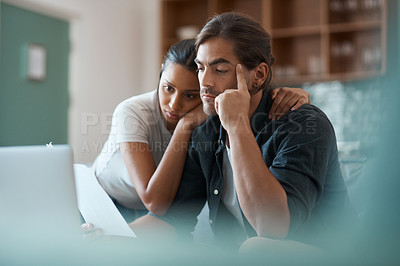 Buy stock photo Shot of a young couple doing paperwork while using a laptop at home