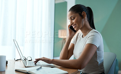 Buy stock photo Shot of a young woman doing paperwork while using a laptop at home