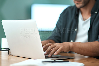 Buy stock photo Shot of an unrecognizable man  doing paperwork while using a laptop at home