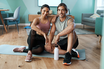 Buy stock photo Full length portrait of an athletic young couple sitting on an exercise mat during their workout at home