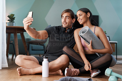 Buy stock photo Full length shot of an athletic young couple taking selfies after their workout at home