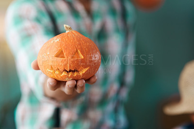 Buy stock photo Shot of an unrecognizable person holding a carved pumpkin