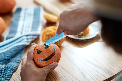 Buy stock photo Shot of an unrecognizable person carving a pumpkin at home