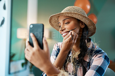 Buy stock photo Shot of a young woman taking a selfie while applying makeup at home