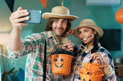 Buy stock photo Shot of a young couple taking selfies while holding buckets at home