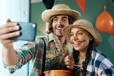 Buy stock photo Shot of a young couple taking selfies while holding buckets at home
