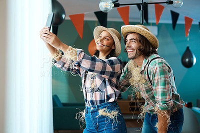 Buy stock photo Shot of a young couple taking a selfie at a party