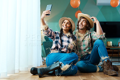 Buy stock photo Shot of a young couple taking a selfie at a party